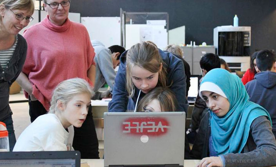 to voksne og fire piger er optaget af computerskærm