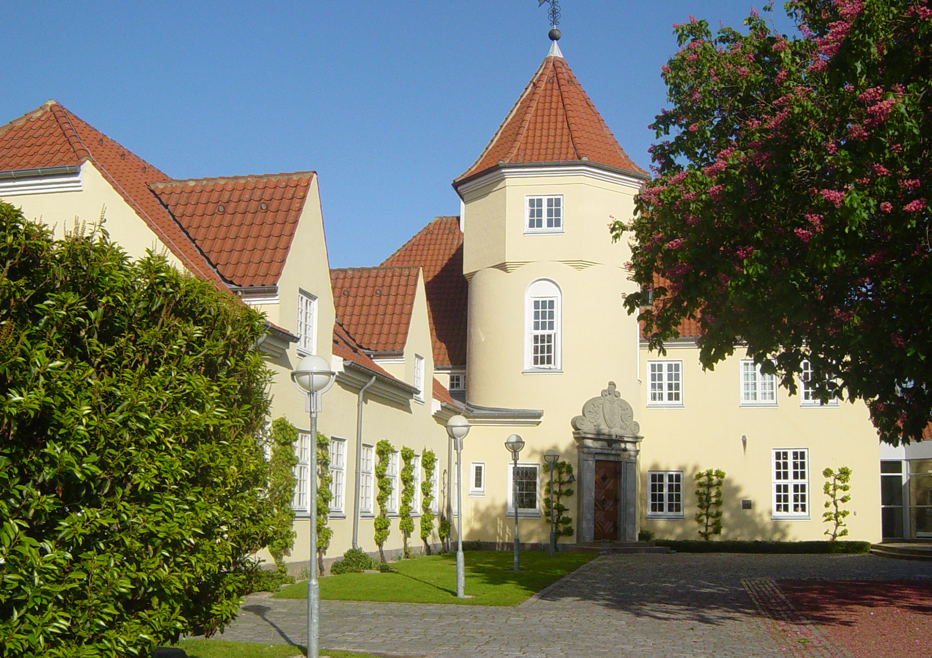 Gammel Avernæs en smuk pastelgul slotsagtig bygning med rødte tegtag