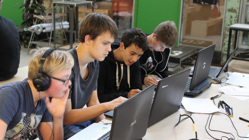 4 drenge arbejder intenst foran bærbare computere
