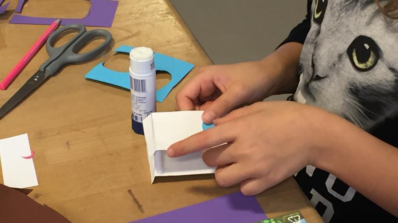 Barn folder papir og limer