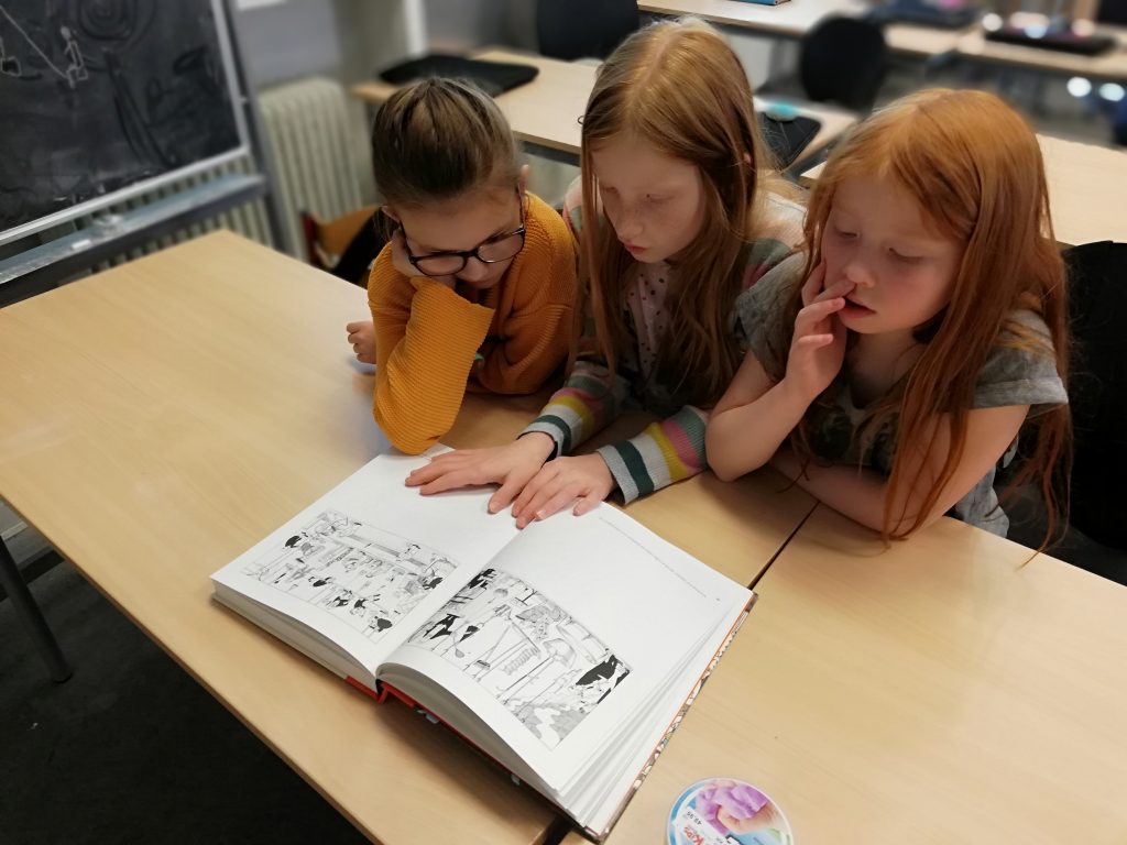 tre elever læser i bog