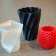 Tre 3Dprintede beholdere i rød, hvid og sort