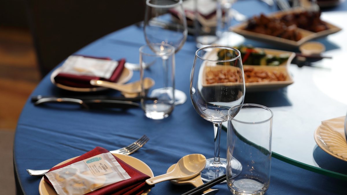 Dækket bord med blå dug, service, vinglas og bordpynt