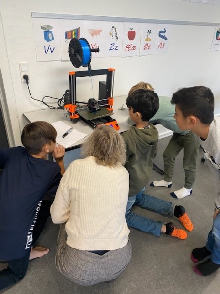 Børn kigger på en 3D printer, der printer