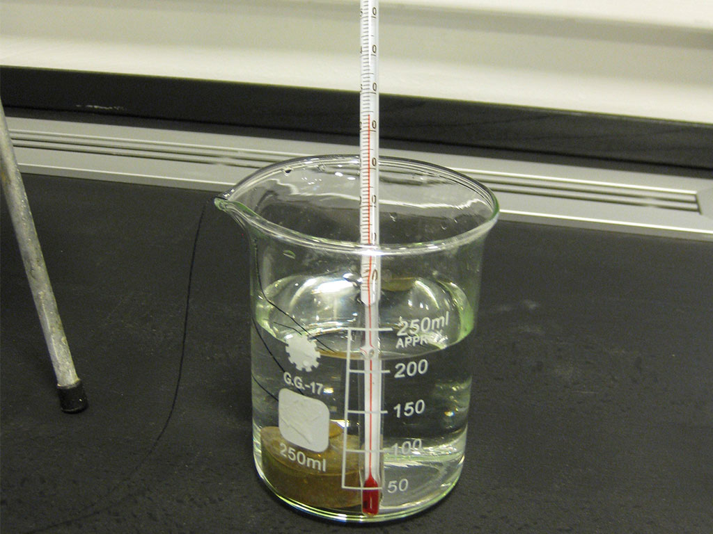 Glas med væske i og termometer